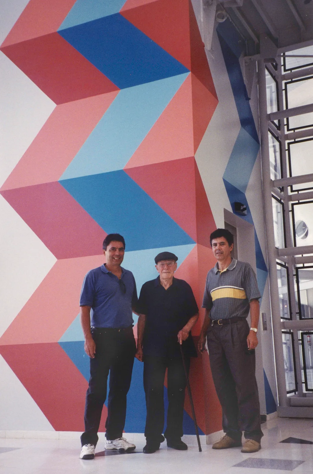 Sacilotto com os filhos Oscar e Valter em frente ao painel do Sesc Santo André, 2002